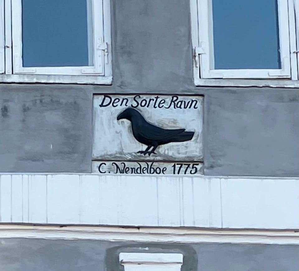 stylized image of a crow painted on a building.