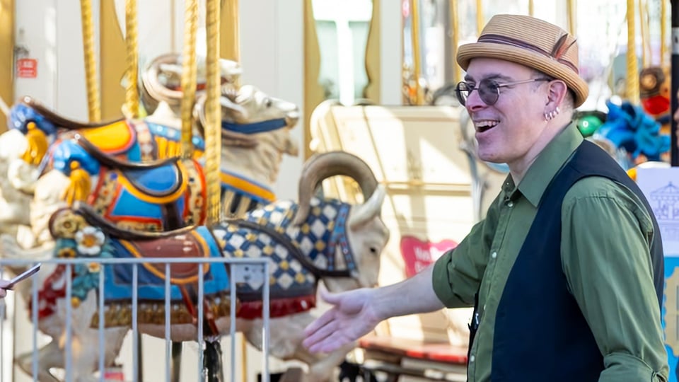 Ryan greeting a guest onto the carousel.