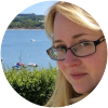 Portrait of Gill in front of coastline and boats