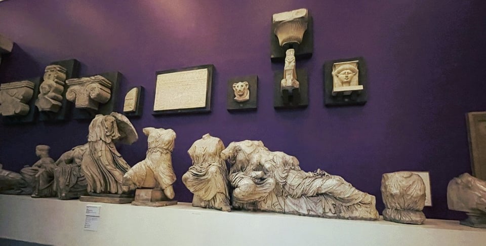 white plaster casts of sculptures against a dark purple wall