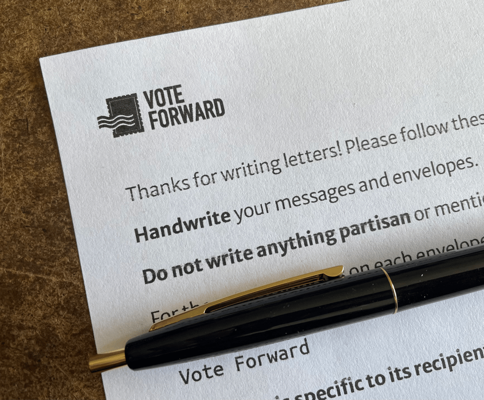 A pen rests on a form encouraging people to vote