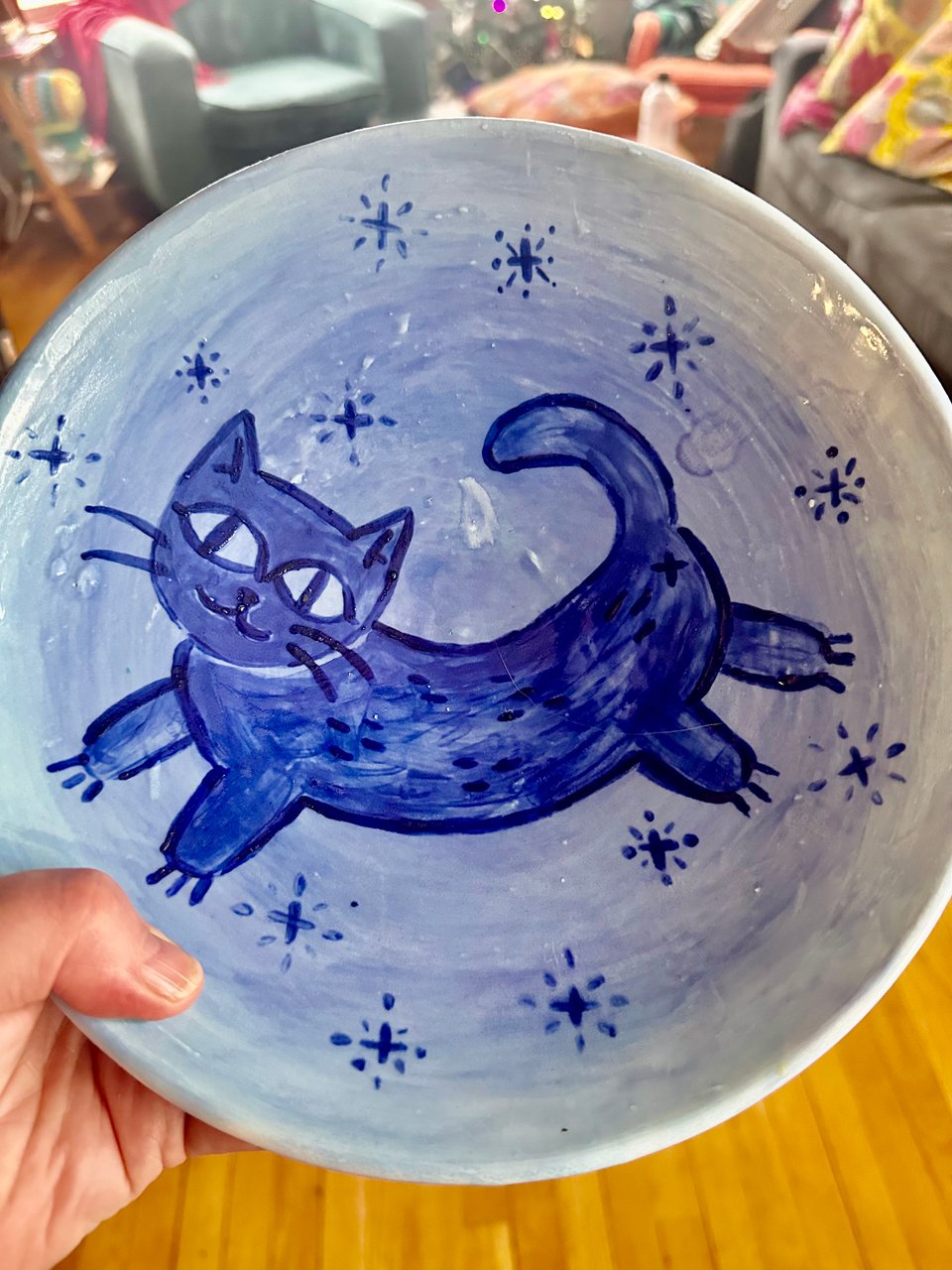 a wide bowl with a cute blue cat painted on it
