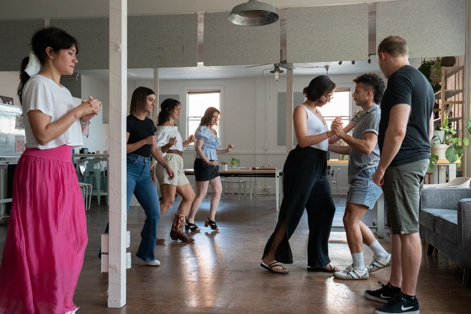 A group of people learning to dance.