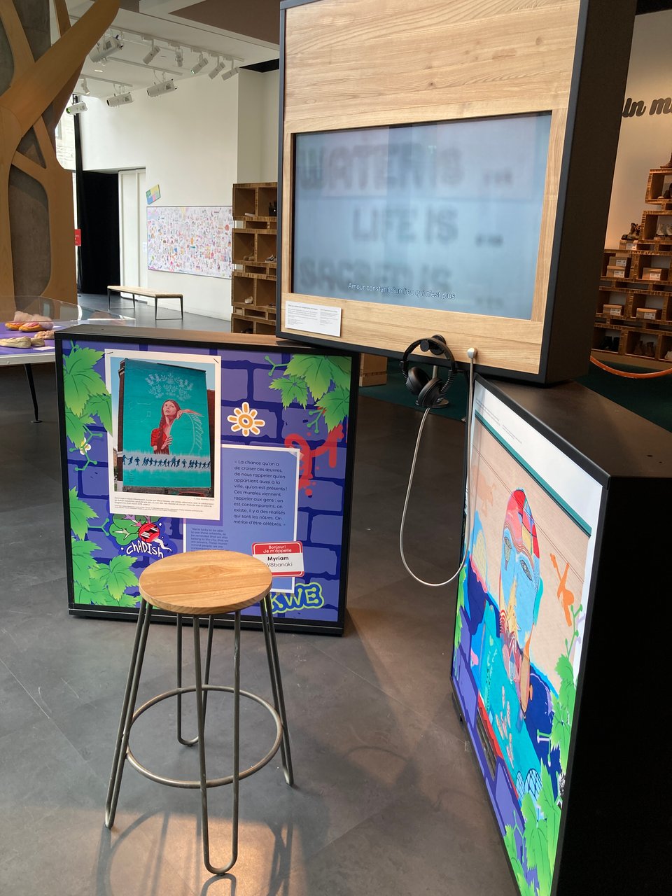 Three colorful modular museum panels in a museum setting with a gray concrete floow