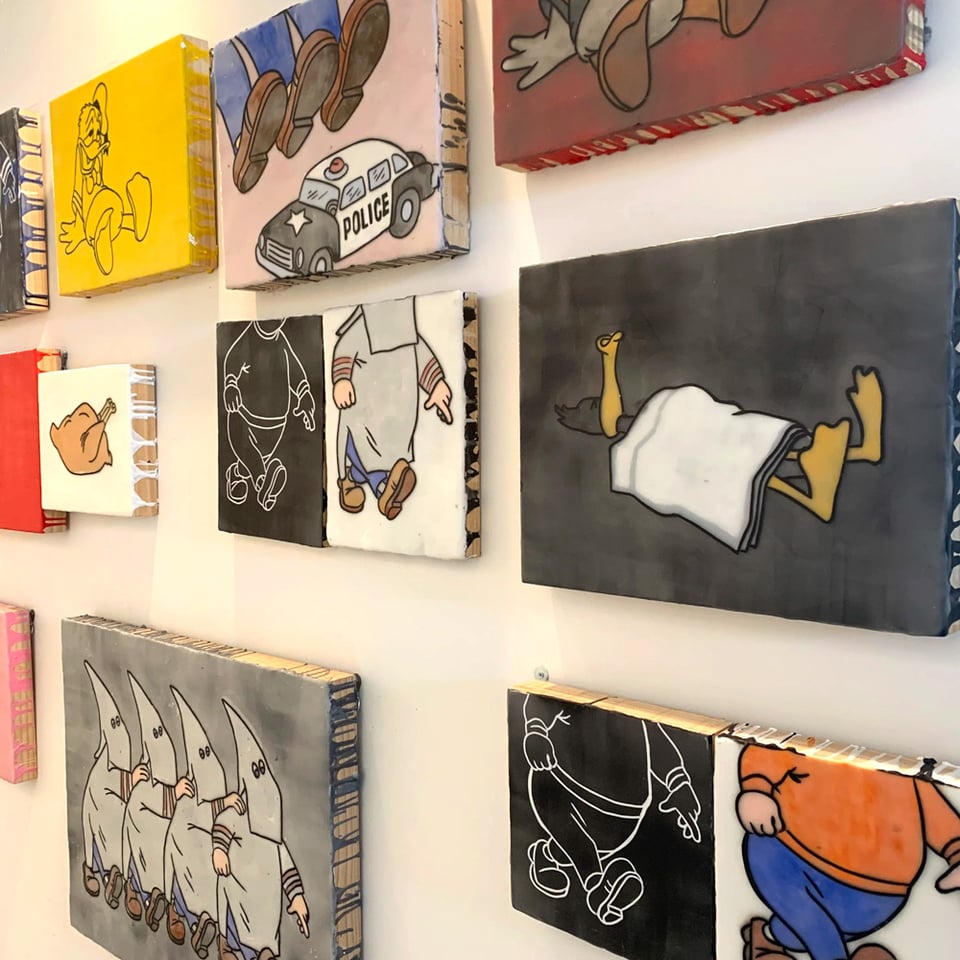 A wall full of small paintings. Dudes walking. Ducks sleeping. Feet stepping on police cars. Etc.