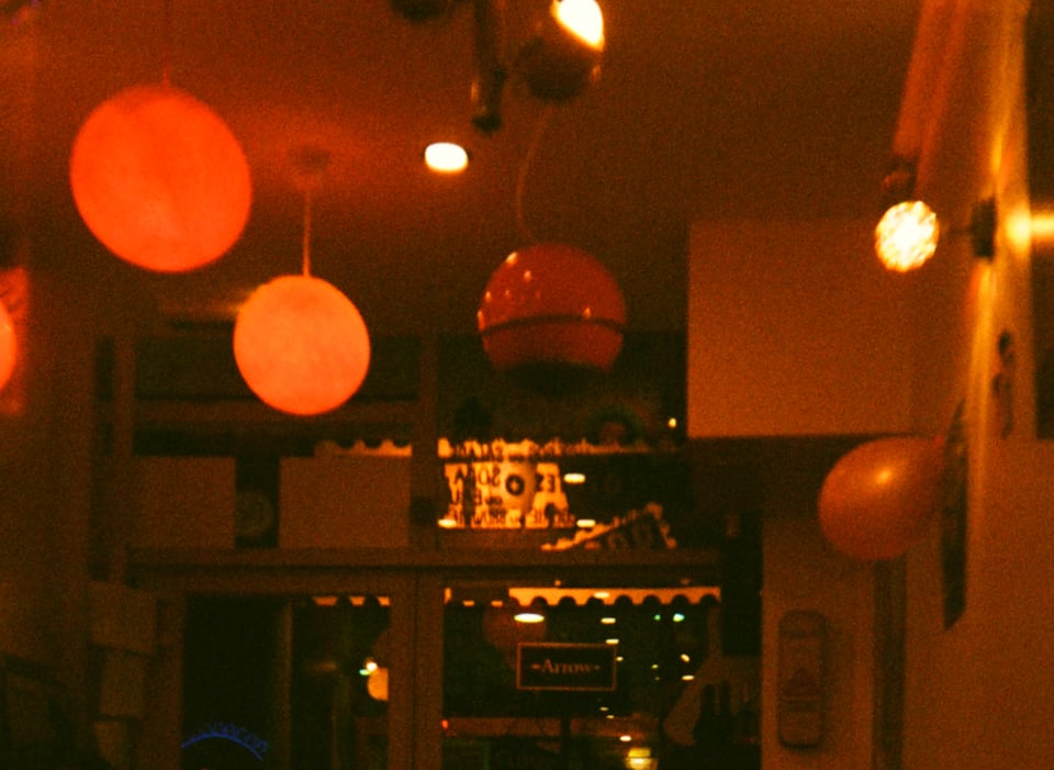 Uma fotografia analógica de uma sala em tons avermelhados.