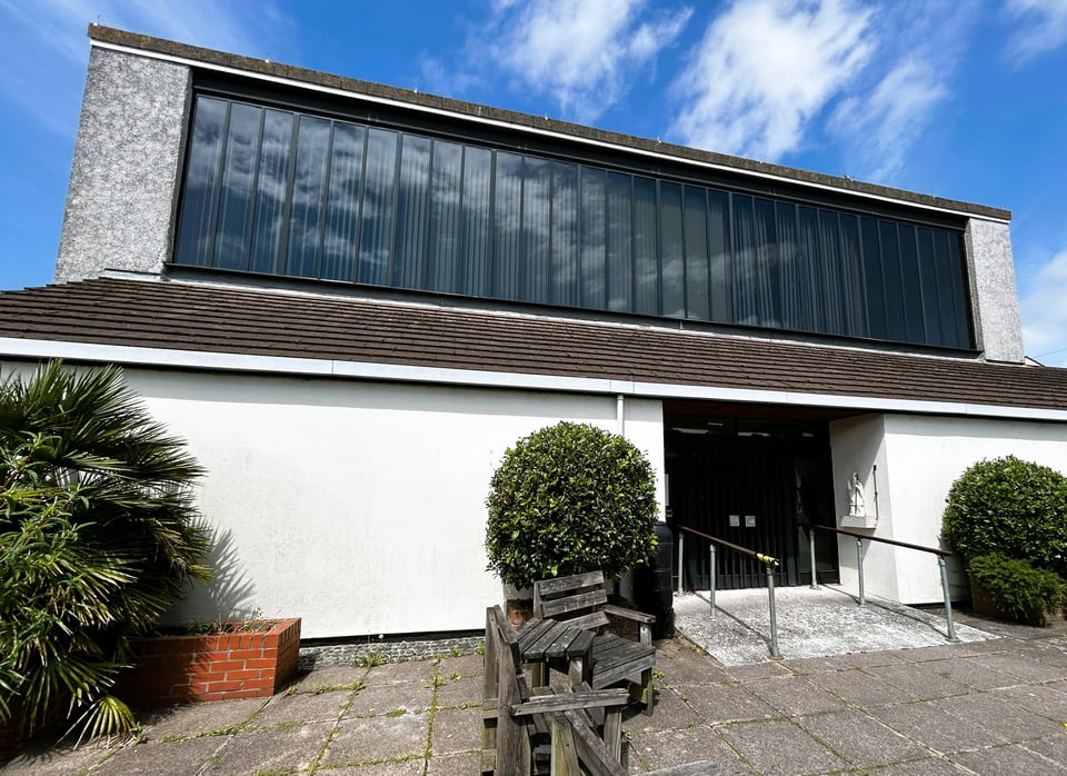 A plain building with a huge, full width window across the second storey.