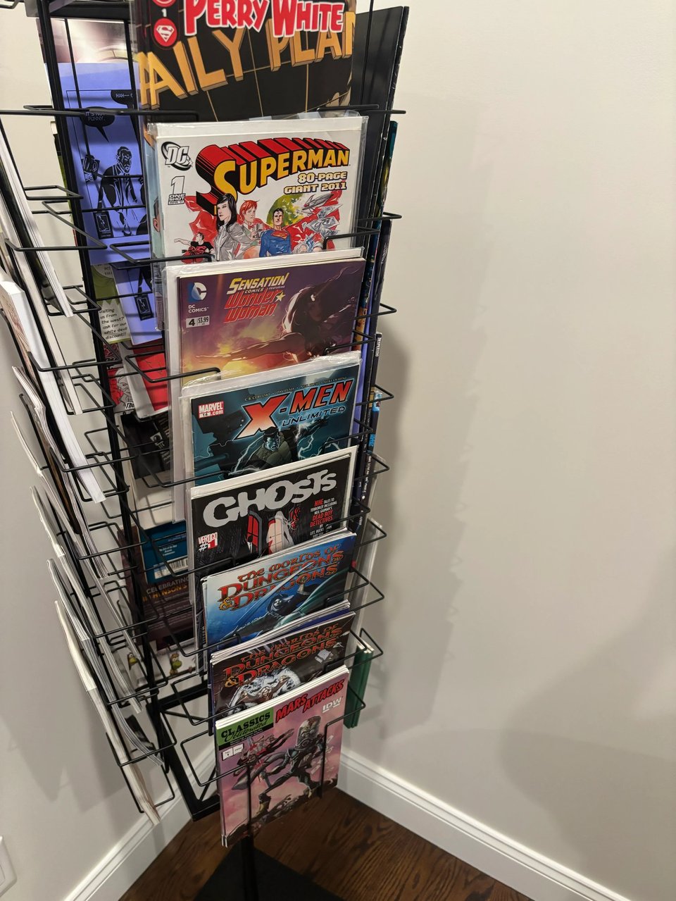 a comic book spinner rack featuring comics with stories written by neil kleid