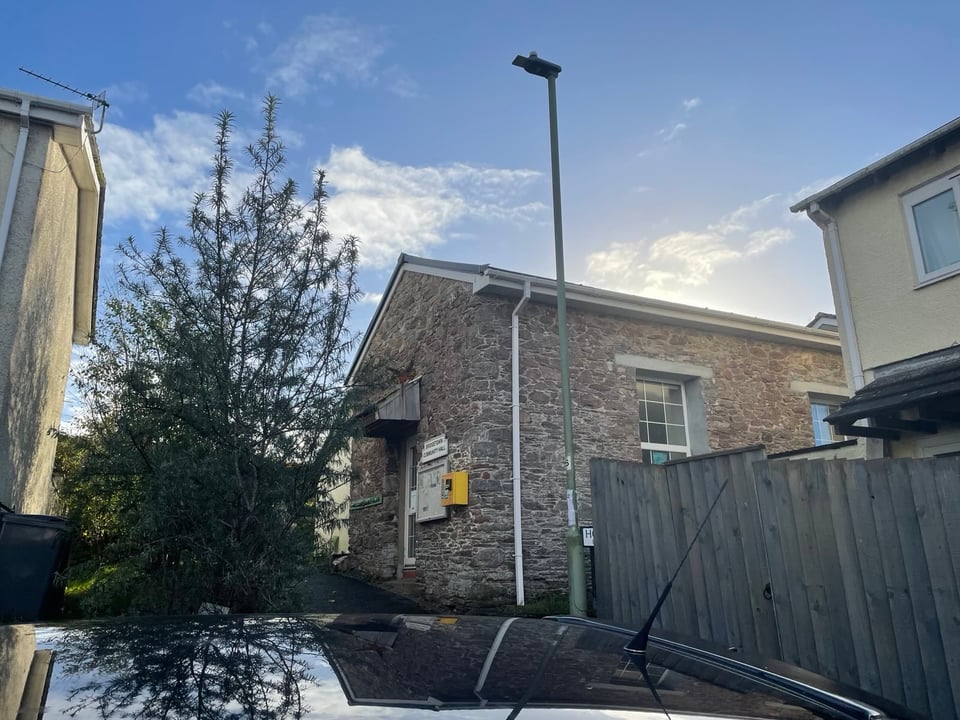 View of the stonewall building of the Bridgetown Community Hall. Photo of the southern angle taken slightly from the bottom as the building is at the top of the square, during a sunny day