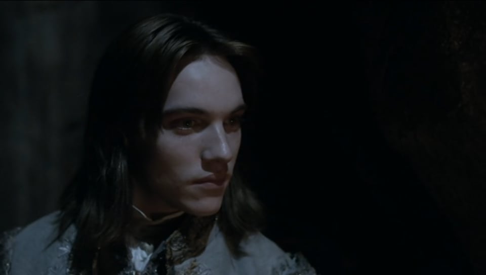A pale young man with dark hair looking intently off to the right.