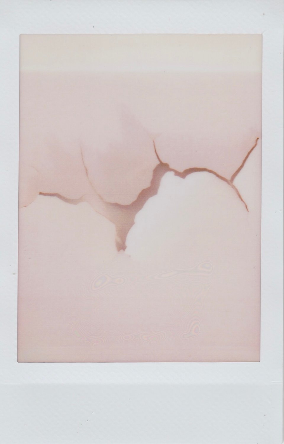 Scan of an Instax print of paint cracking on a wall