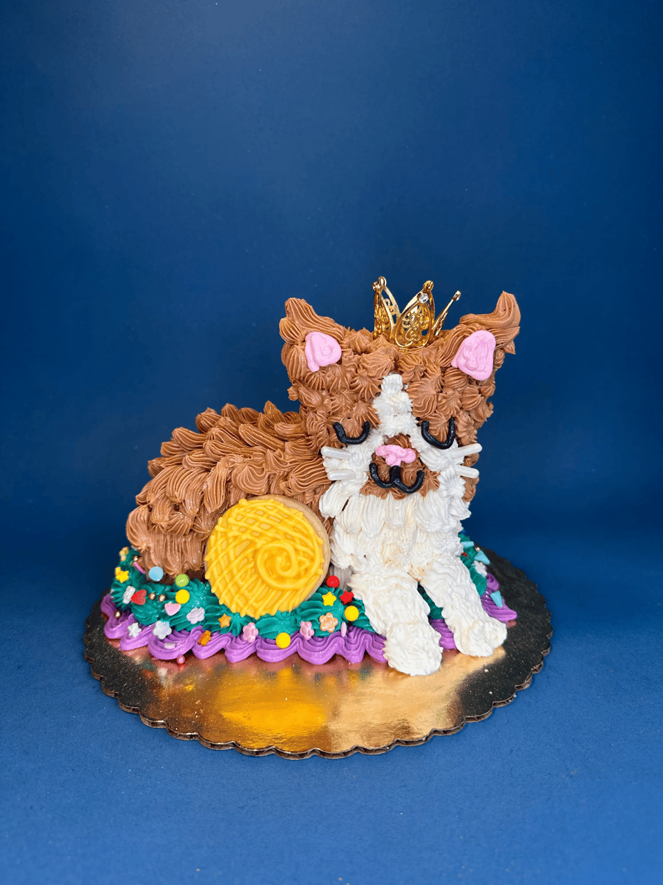 A cake that looks like a derpy orange cat with his eyes closed