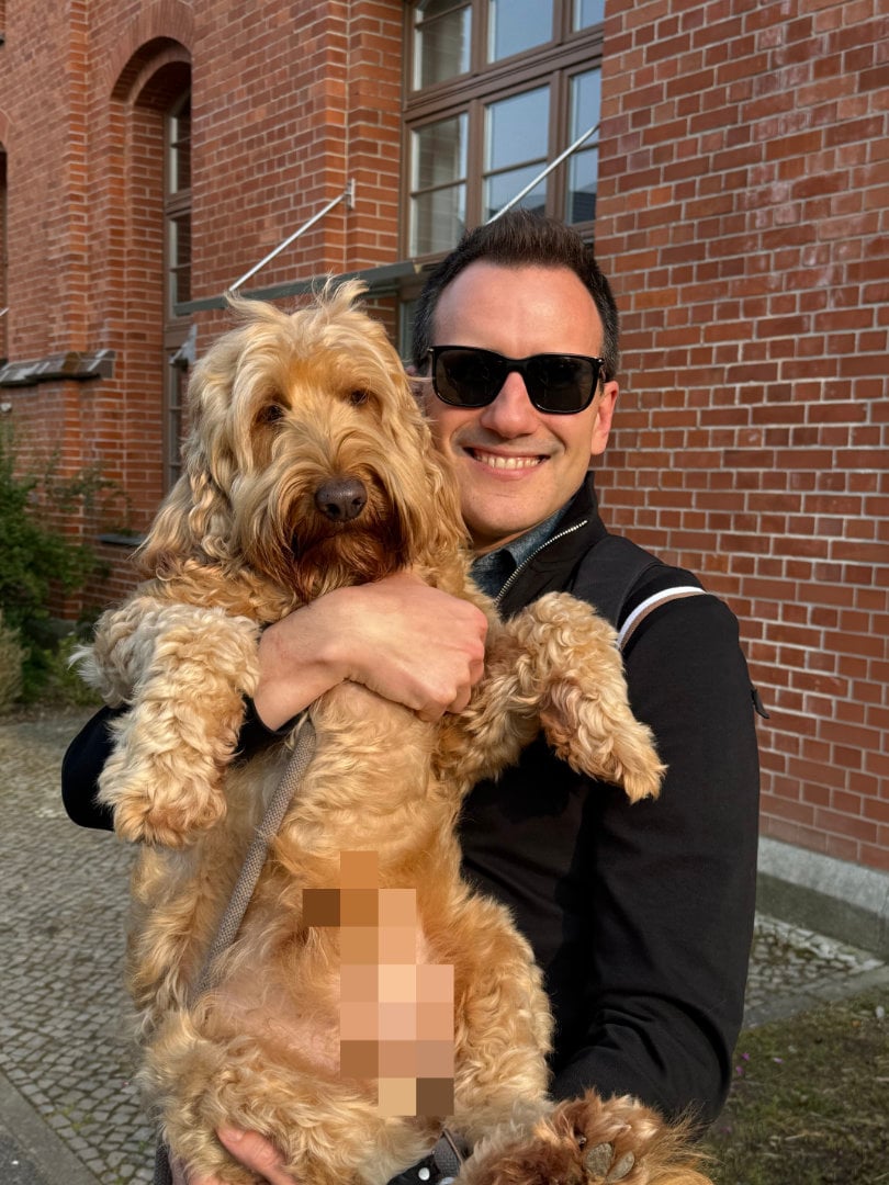 Me holding up an 11+ cute golden doodle with pixelation in his nether regions for his modesty.