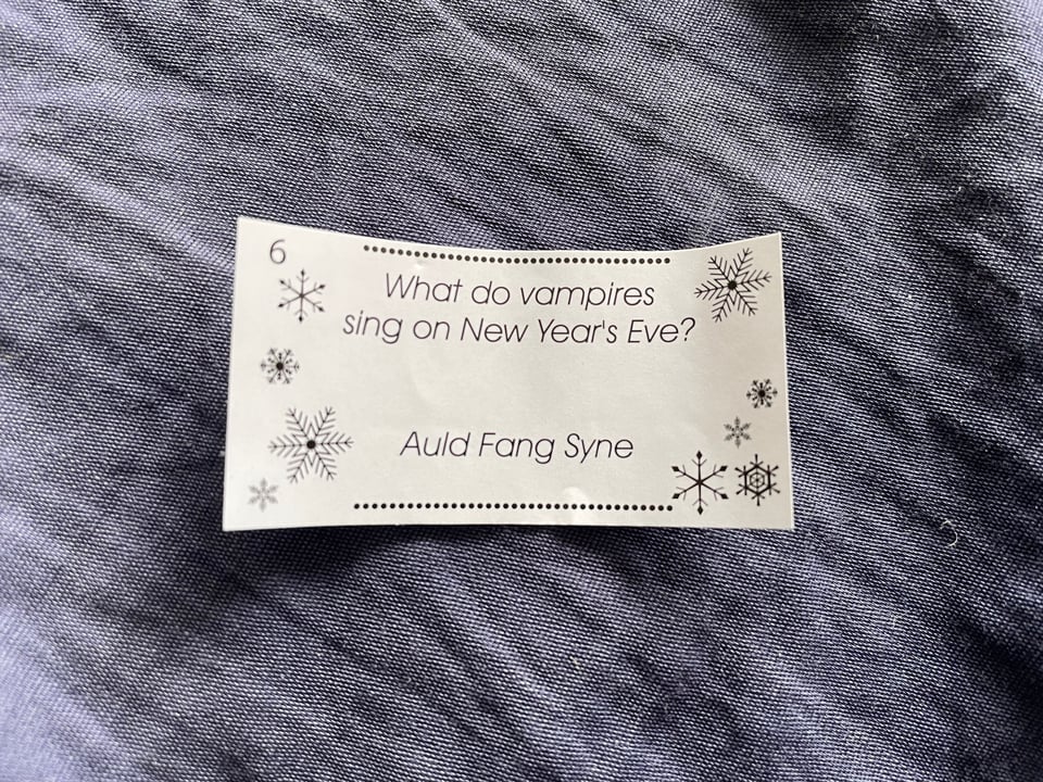 A slip of paper with a dumb joke that reads: What do vampires sing on New Year's Eve? Auld Fang Syne.