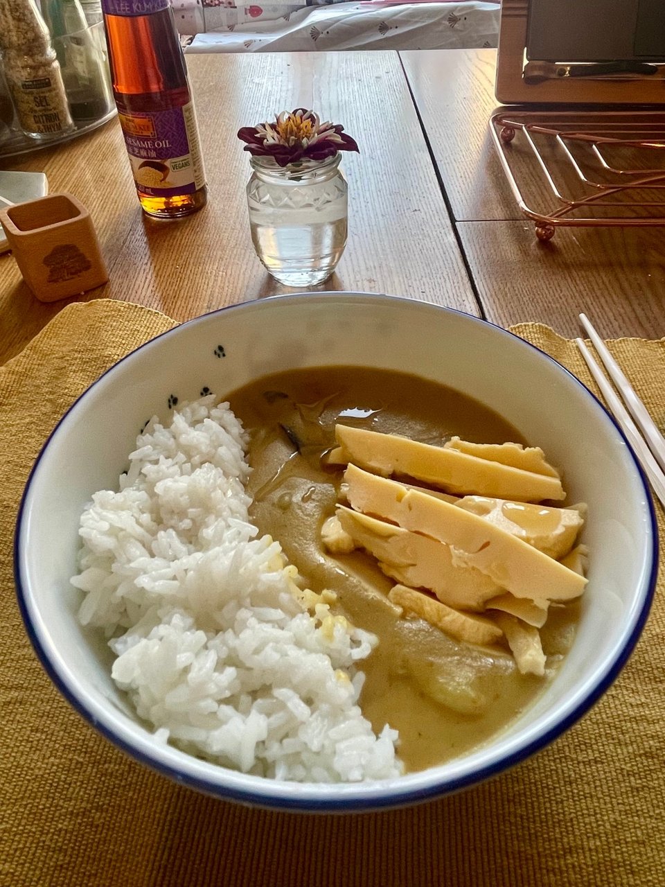 A bowl of rice and curry with steamed egg on top