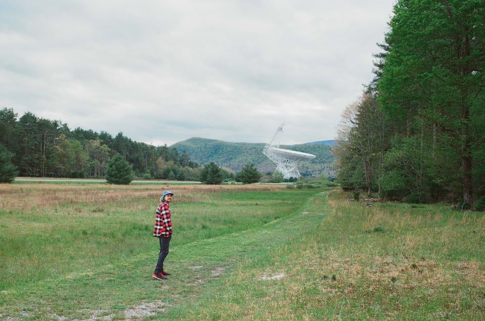 Dan in flannel in front of a giant radio telescope