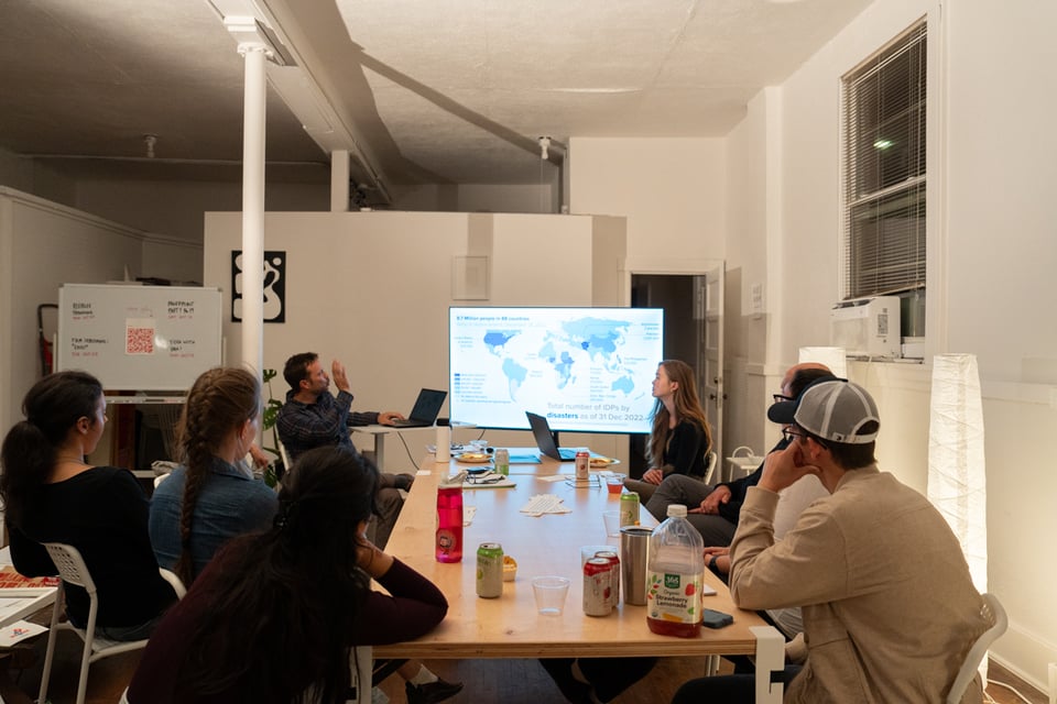 A crowd looking at a screen.
