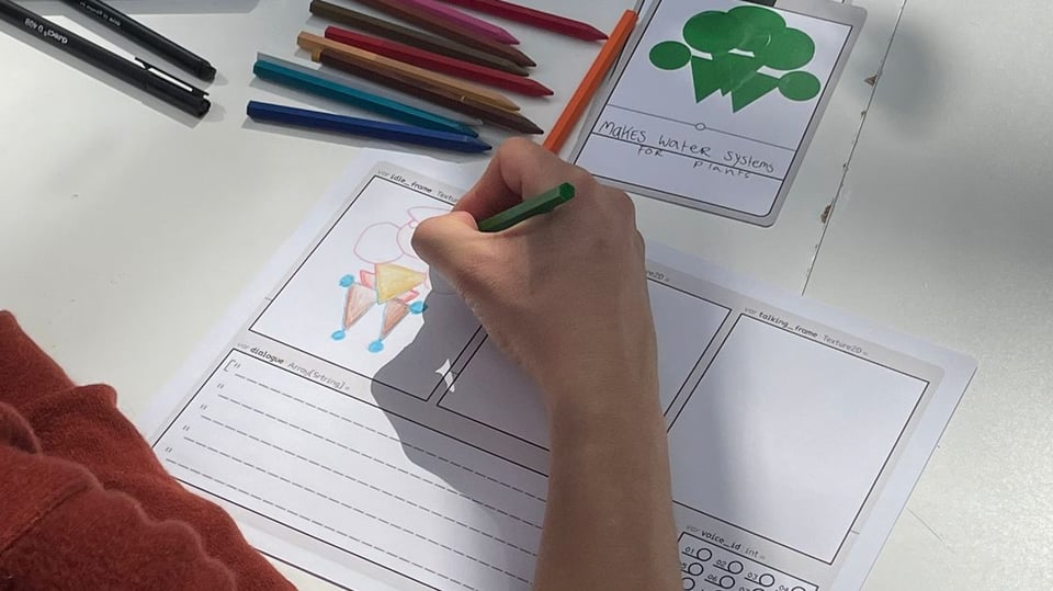A person draws with colour pencils on a piece of paper.