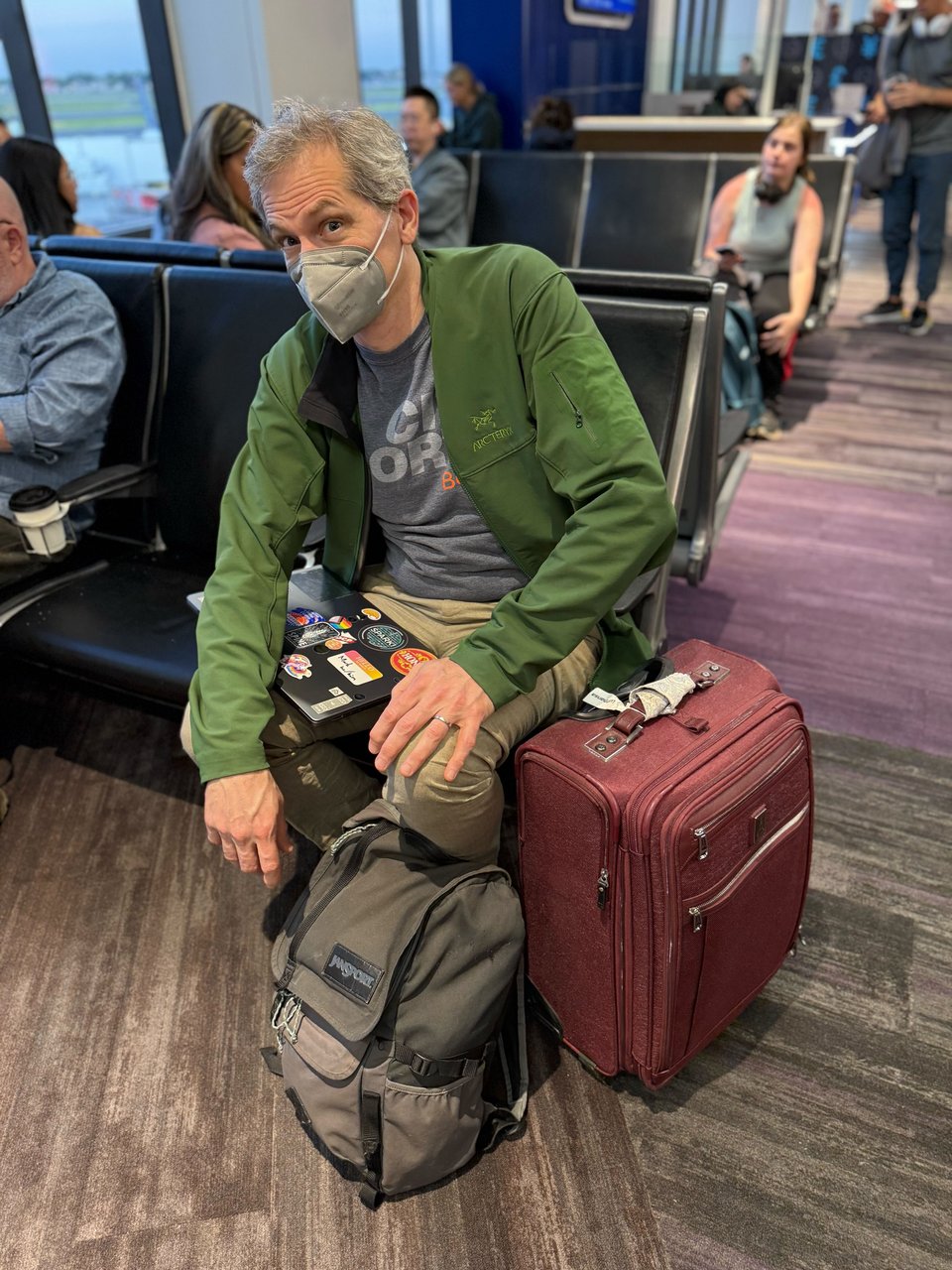 Mark sitting in the airport terminal looking ready for travel.