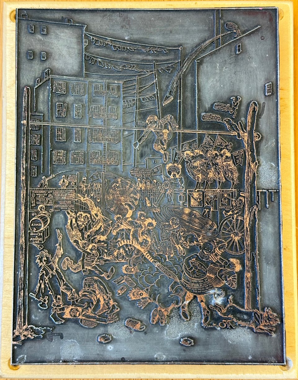 Image of Yellow Kid printing plate showing (mirrored) a scene of the kid running with a football and other children around him playing a mock football came with the backdrop of tenement buildings