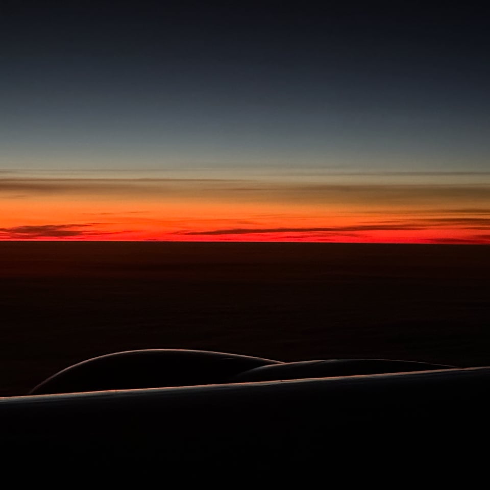 photo of sunrise from an airplane, with the wing & engine barely illuminated in the foreground. It's haunting, and I wish you could see it.