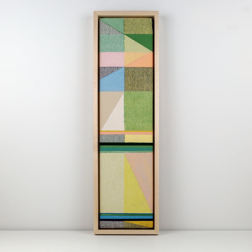 A tall, narrow framed artwork featuring a woven textile overlaid with geometric painted shapes in pastel pinks, yellows, blues, greens, and neutrals, divided into sections of triangles and rectangles.