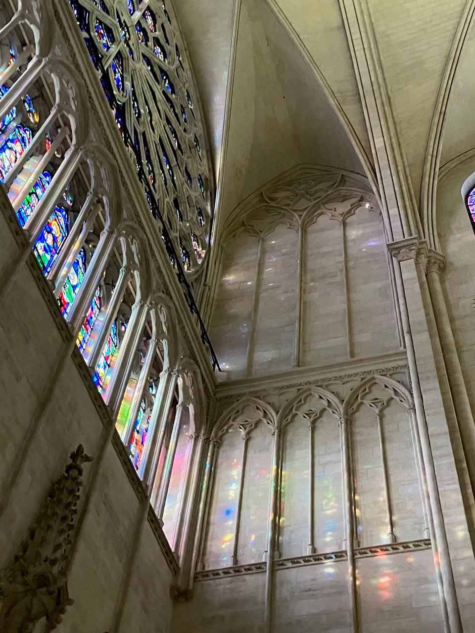 Stained glass window shining onto a church wall.