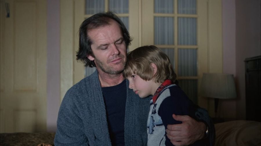 Jack, who obviously hasn’t shaved in days, wraps one arm around Danny who sits in his lap. Both of them seem ill at ease.