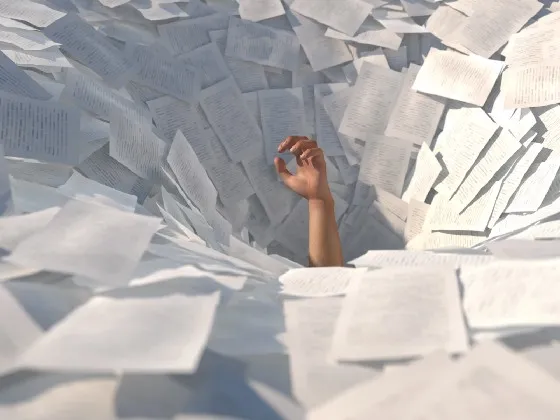 a person's hand in a pile of paper