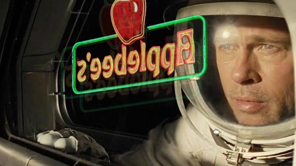 Brad Pitt in a space suit with an Applebee's logo reflecting over him