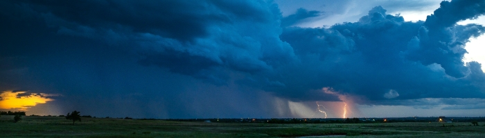 lightning in the sky under large blue clouds