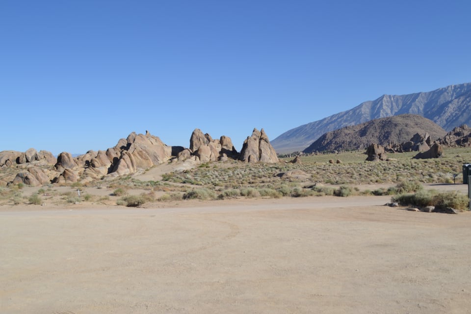Open desert with sharp rocks and mountains in the background.