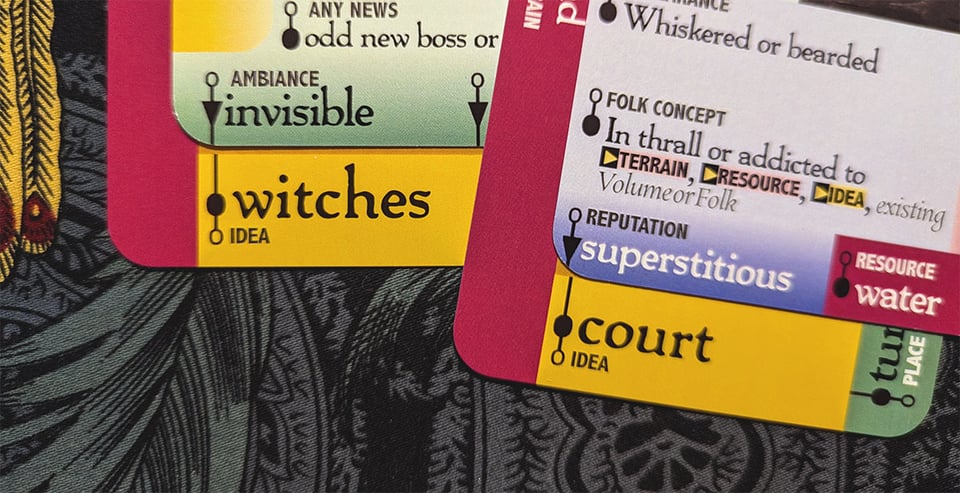 Downcrawl deck cards aligned to form the prompts "invisible witches" and "superstitious court."