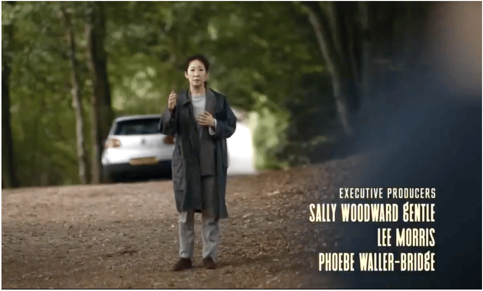 Screenshot of Eve standing in country road facing the camera. The names of the executive producers appear in the bottom left corner: Sally Woodward Gentle, Lee Morris, and Phoebe Waller-Bridge
