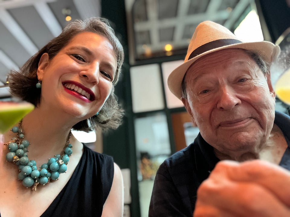 selfie of woman in turquoise bauble bead necklace with man in Panama hat at Union Square Cafe