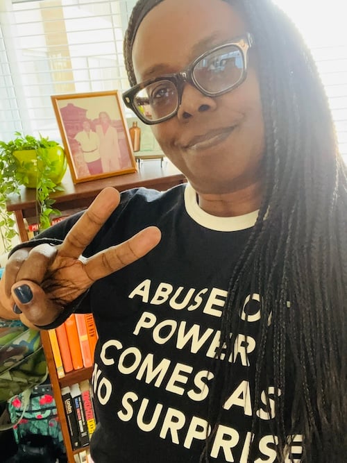 a woman wearing a t - shirt that says abuse of power comes as no surprise