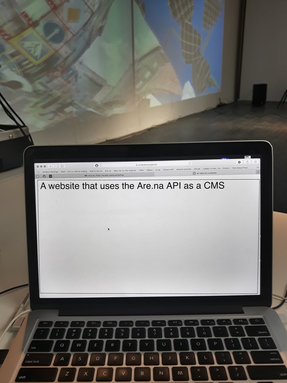 A photo of a computer screen with a browser opened to a webpage with a white background and black type: “a website that uses the are.na API as CMS.”