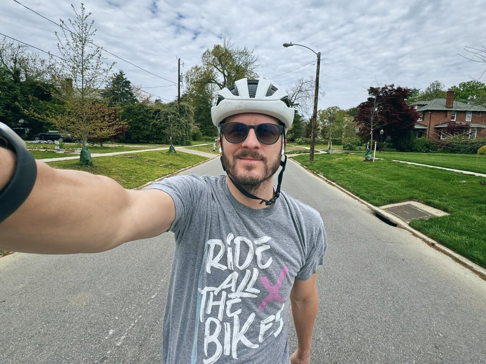 A selfie of the author taken while riding a bike. He’s wearing a shirt that says “Ride all the bikes”