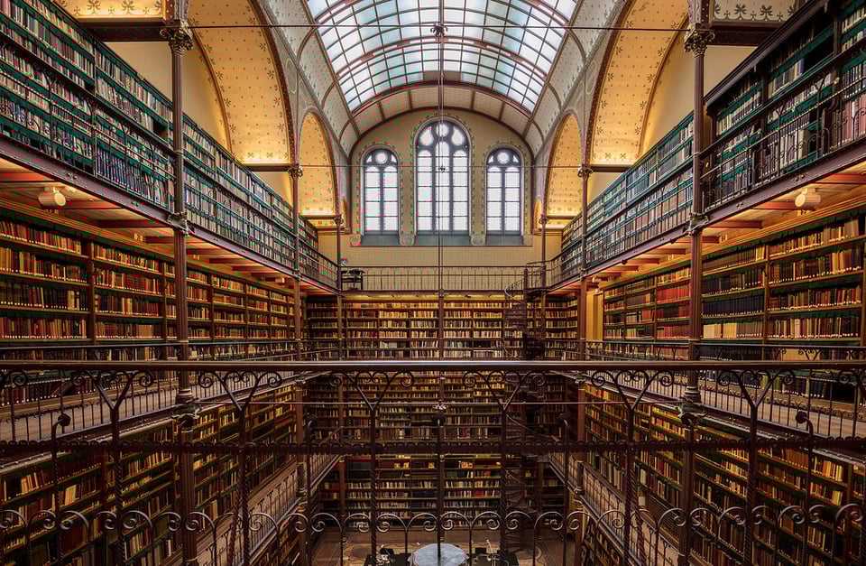 A four-story old library with thousands of books and a curved glass ceiling.