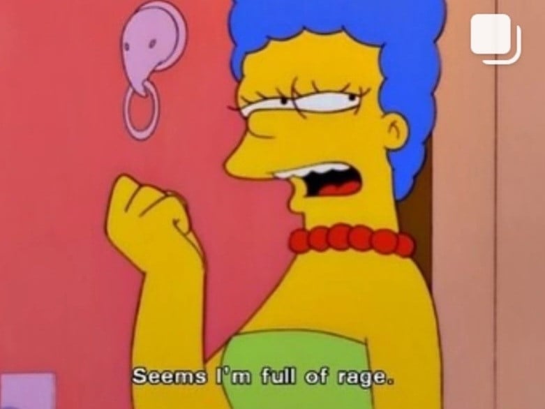 A screenshot from The Simpsons of Marge standing outside the front door of the Simpsons house with a clenched fist, saying: Seems I'm full of rage.