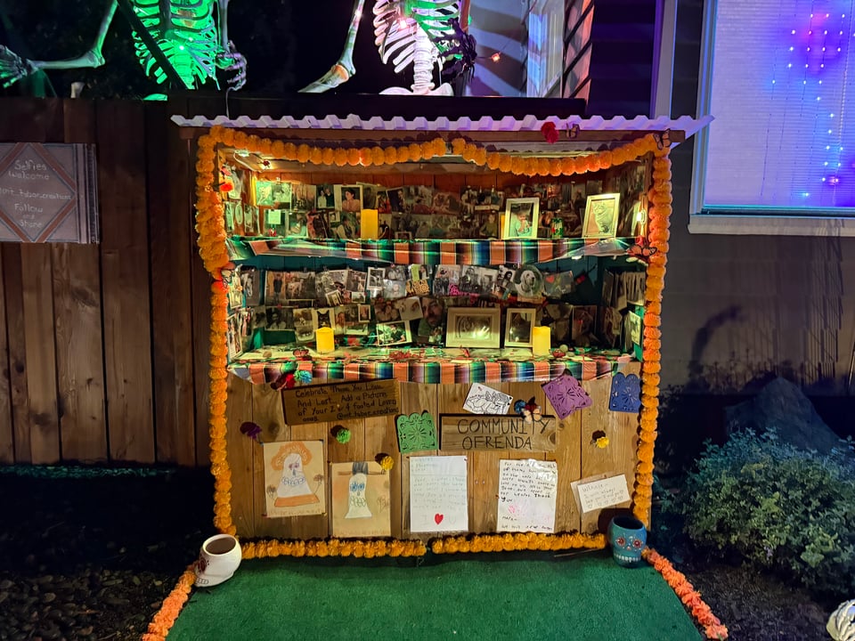 A large, charming ofrenda or shrine to those who died in the past year. It has a sign reading "community ofrenda" with signs indicating that you can leave photos of pets or loved ones, and many have done so.