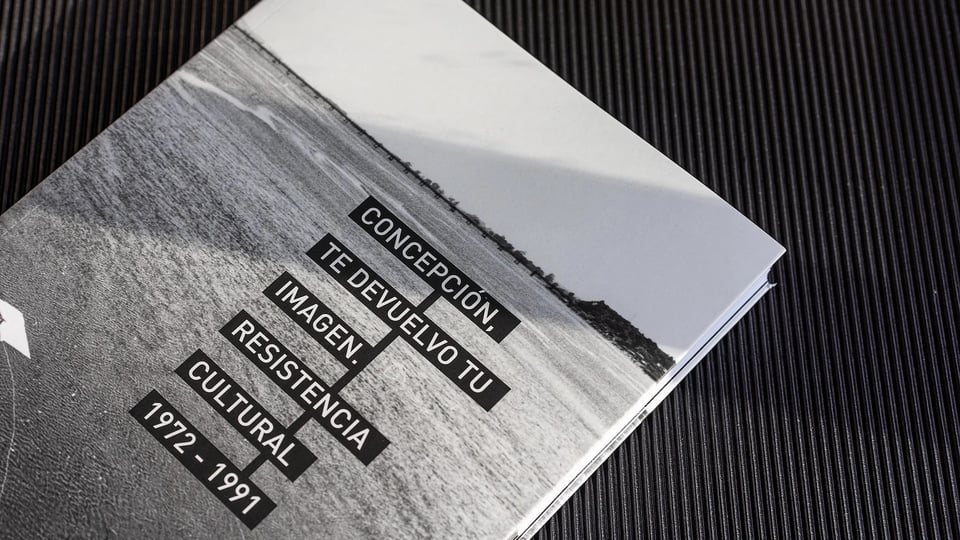 A copy of "Concepcion, Te Devuelvo Tu Imagen," which has a black and white cover with an image of a river.