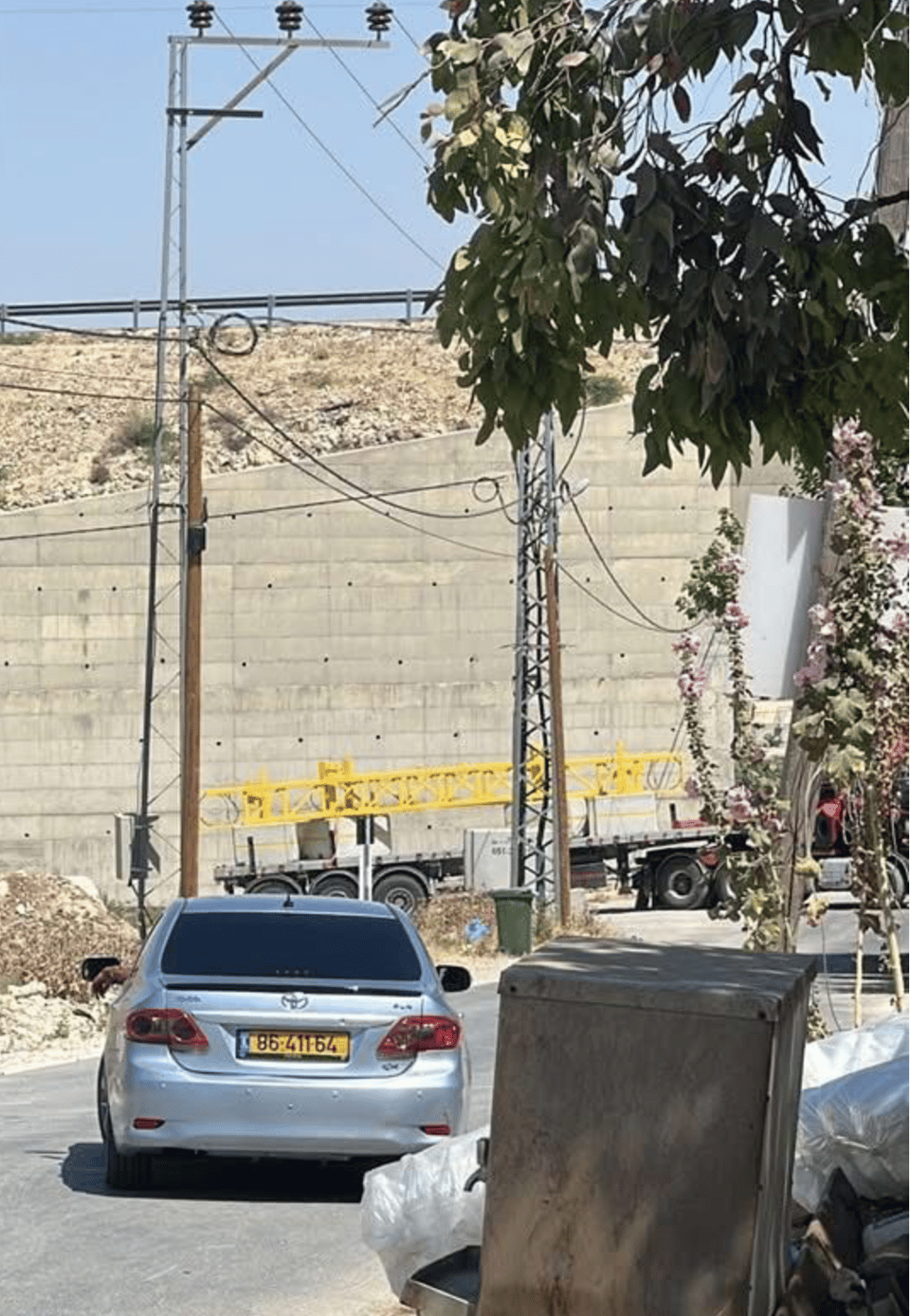 A car on a road with a large yellow metal gate