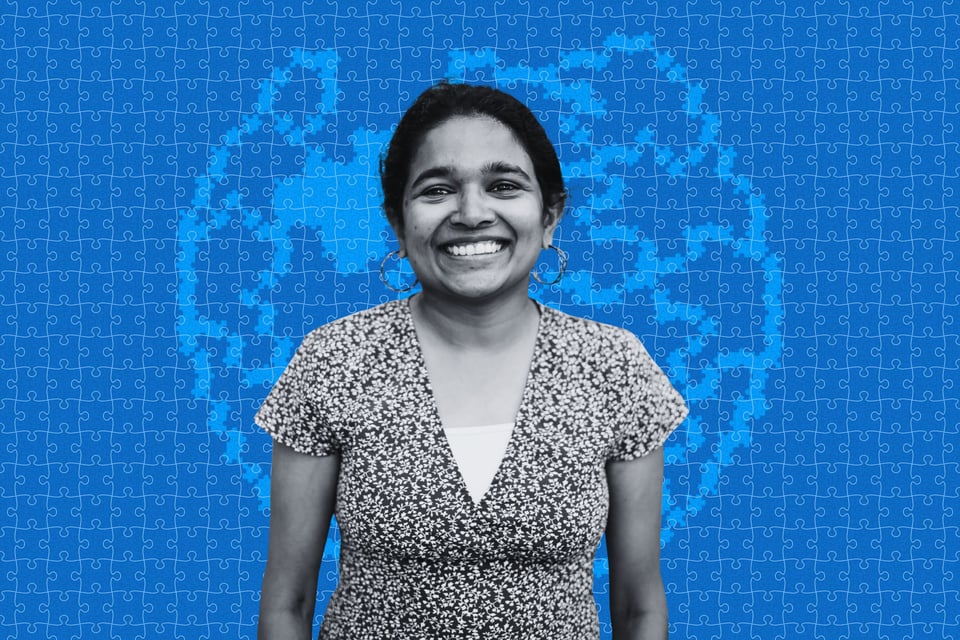 An Indian woman with a blue background containing the Wikipedia puzzle globe logo