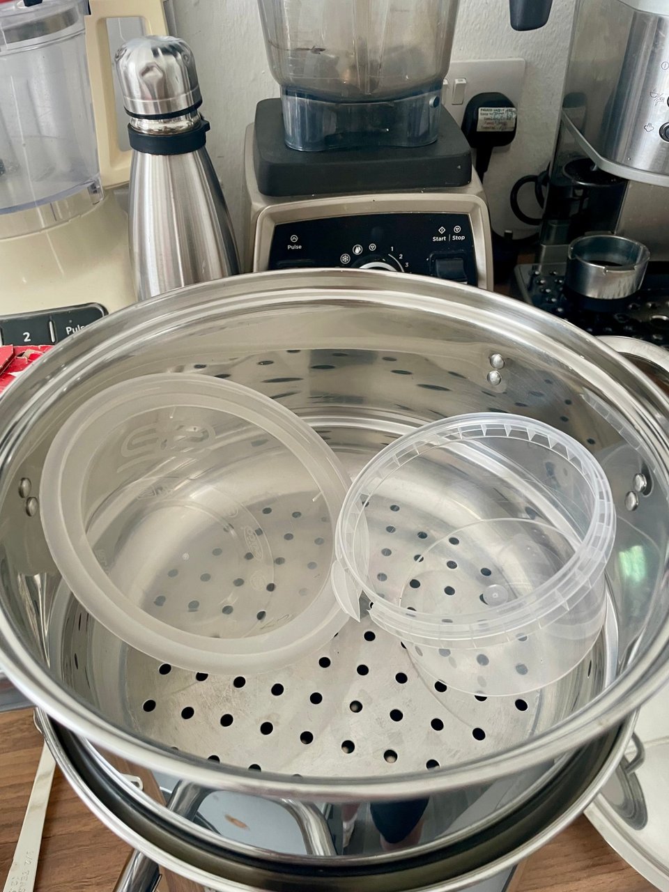 Two clear plastic tubs not quite fitting into a steamer