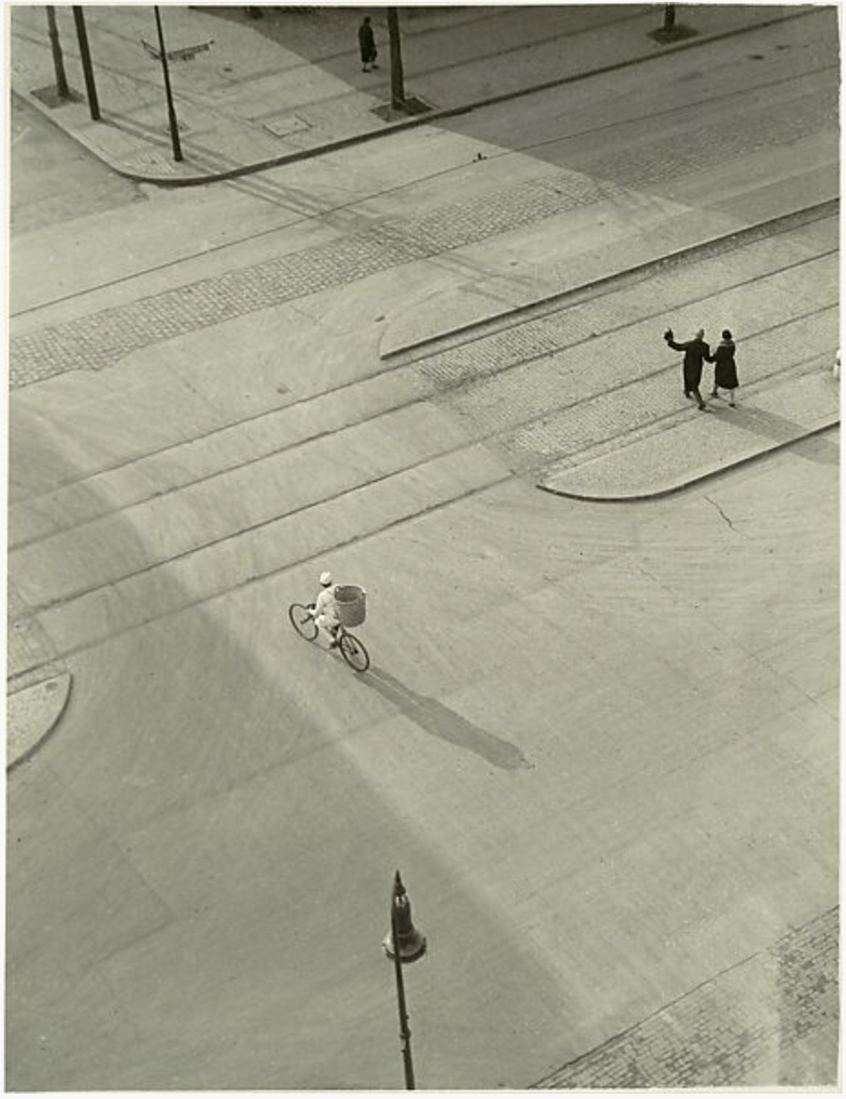 A few scattered people walk over a New York City street lightly swept with snow