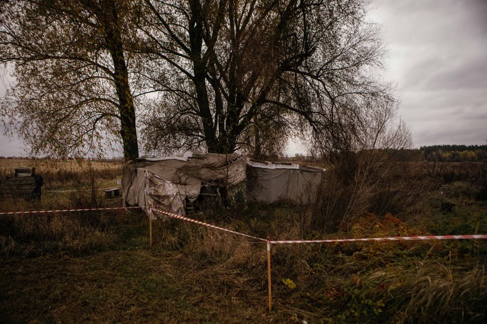 A parcel of agricultural field appears barricaded, with trees in the distance.