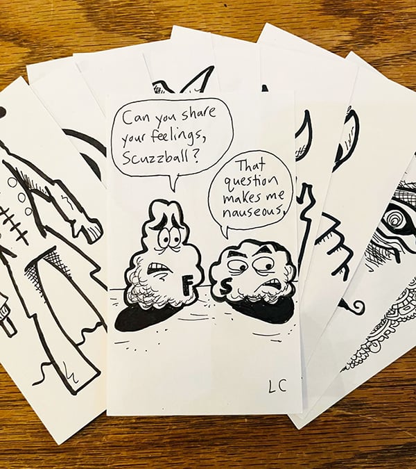 Some index cards with drawings on them, spread out; cartoon characters Fuzzball & Scuzzball are visible, as is a robot