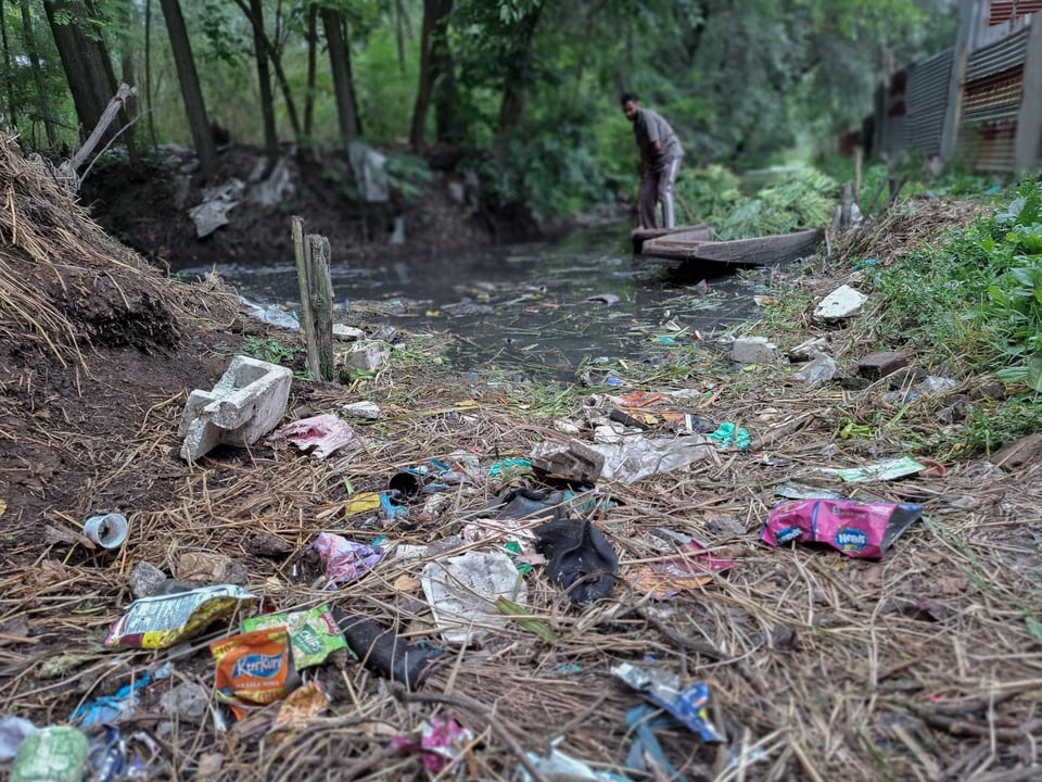 Garbage lies along the banks of Anchar Lake in Soura, Srinagar