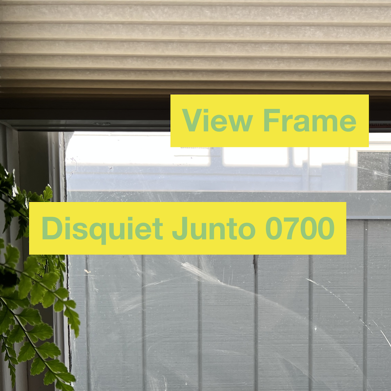 View out a window with a little bit of a plant in view, plus name and number of the project